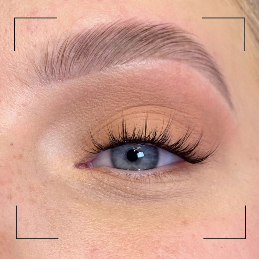 Close-up of a person's eye with makeup, including eyelashes and eyeliner.