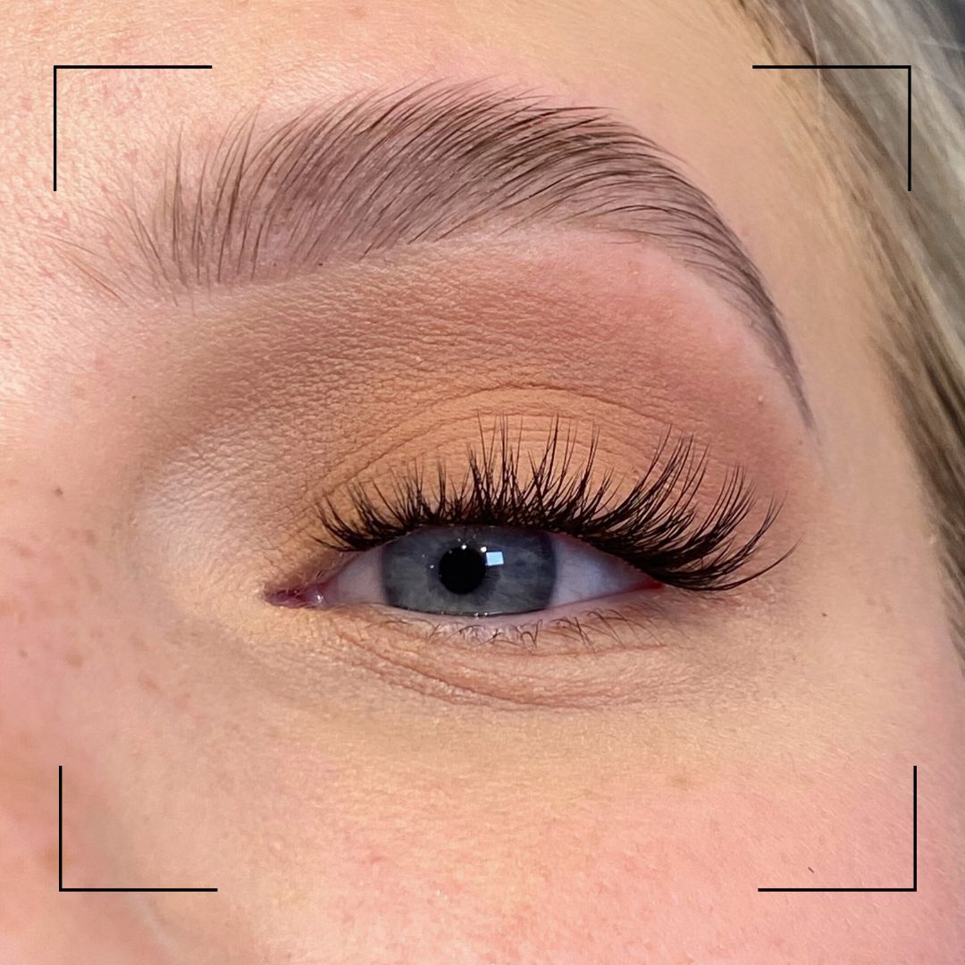 Close-up of an eye with false eyelashes on a neutral background